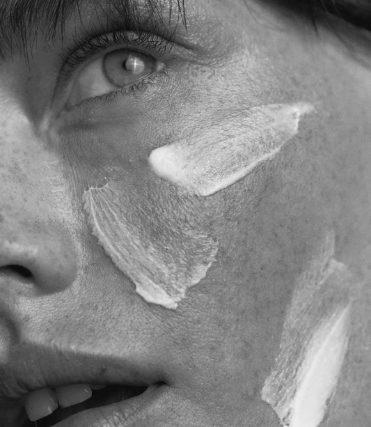 Model with radiant, hydrated skin applying African Botanics Intensive Recovery Cream, demonstrating night-time skin regeneration routine.