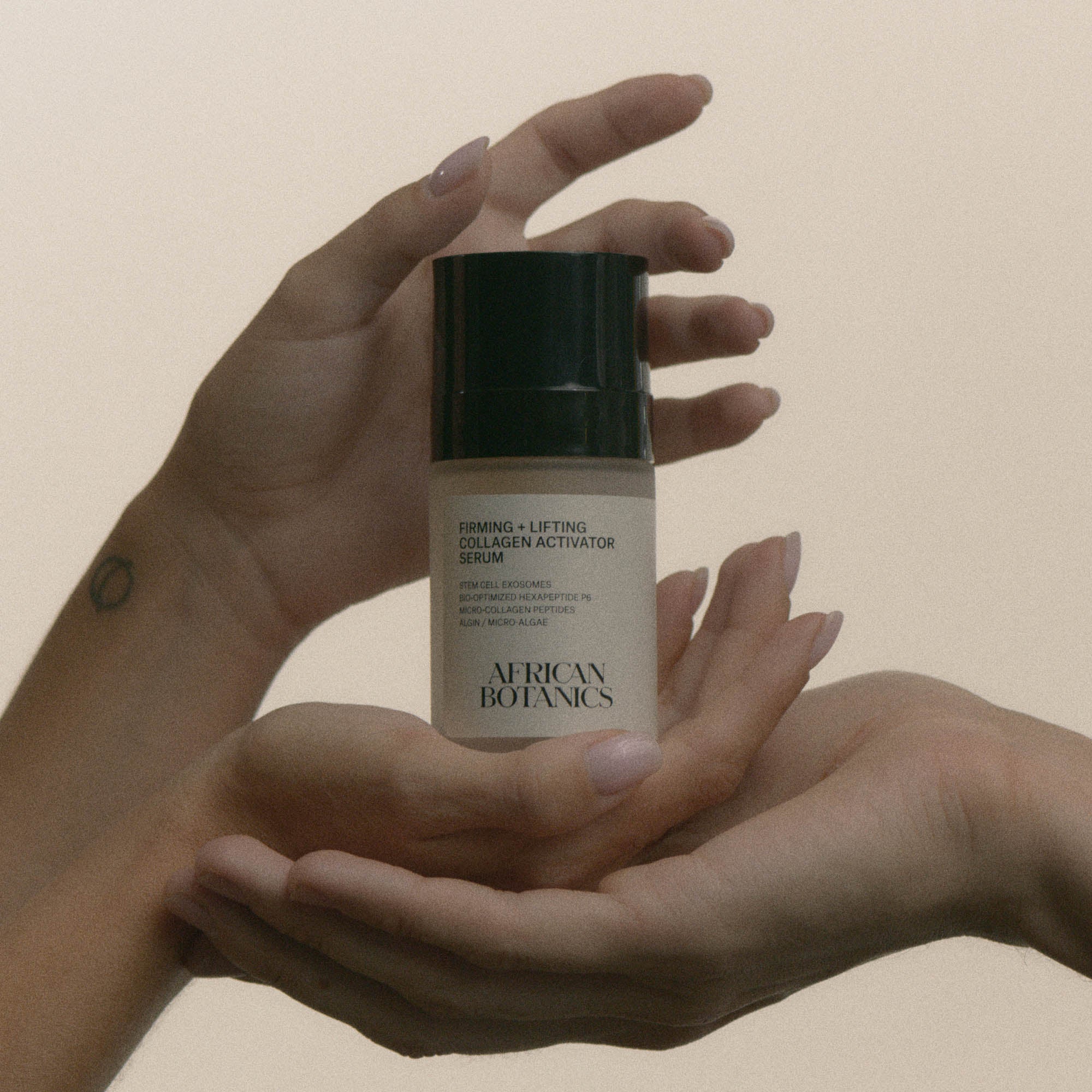 Luxury skincare ritual featuring African Botanics Firming + Lifting Collagen Activator Serum in hands