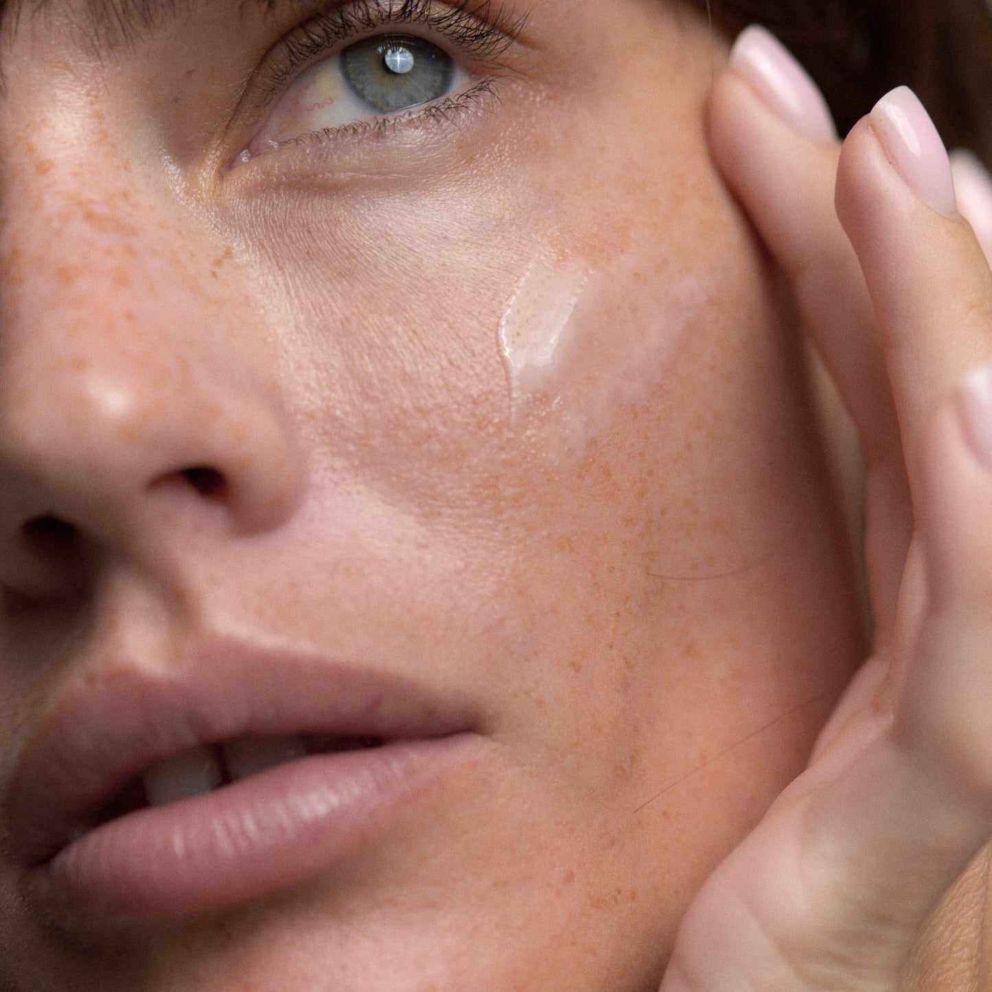 Model applying African Botanics Vitamin C and multi peptide serum to face